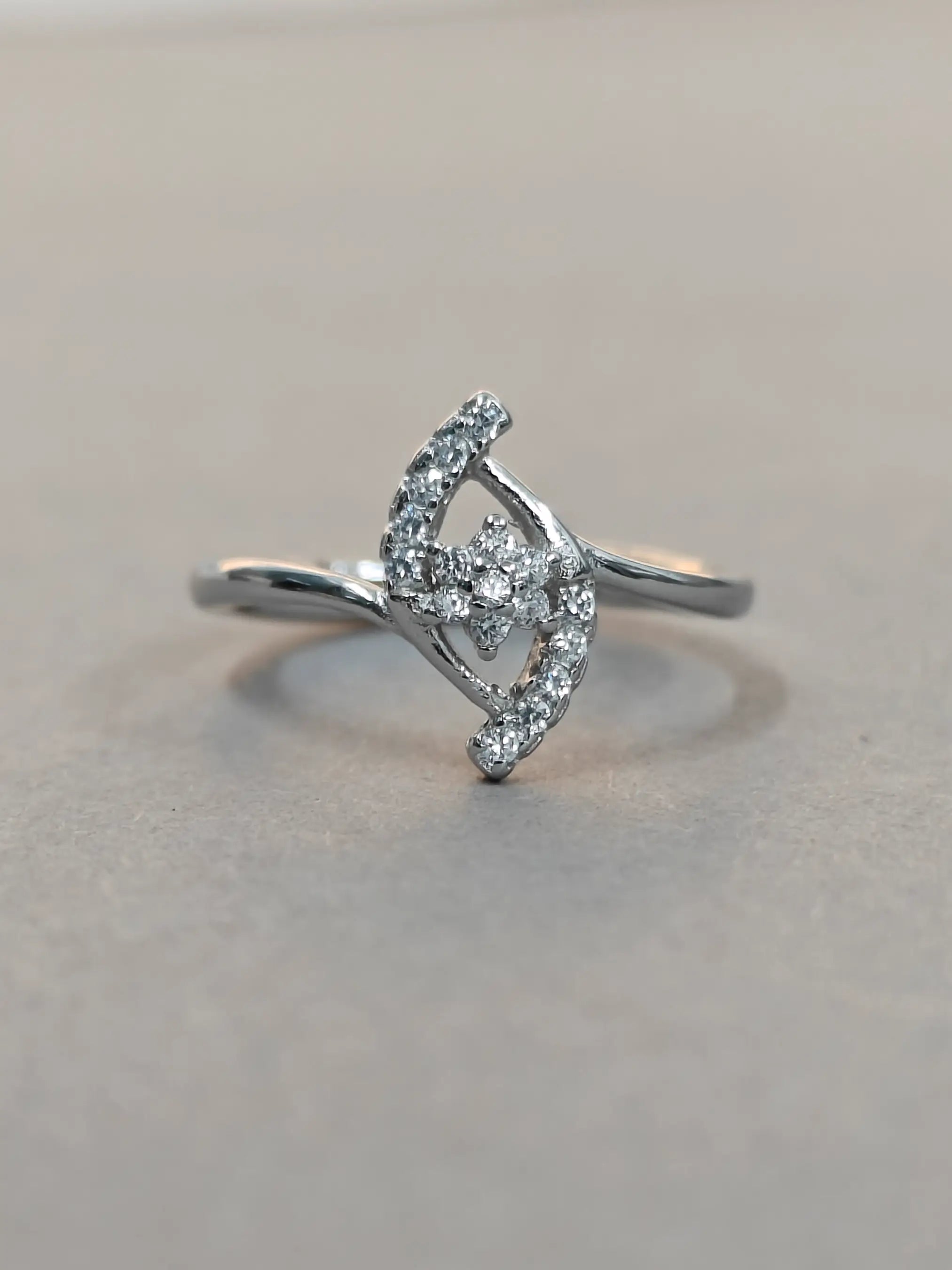 Silver ring with diamond accents on a light gray background